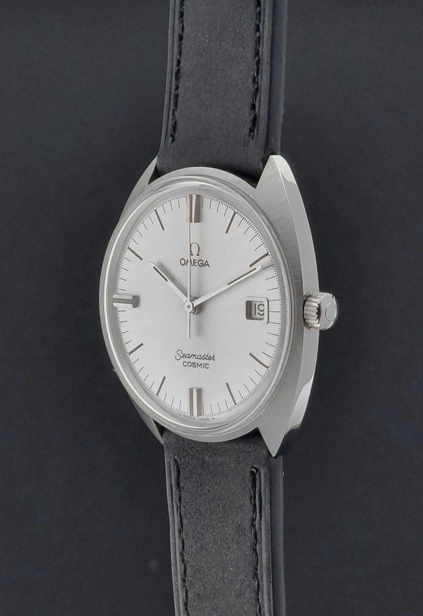 Omega Seamaster Cosmic 136.017 watch with silver dial and black leather strap on a dark background