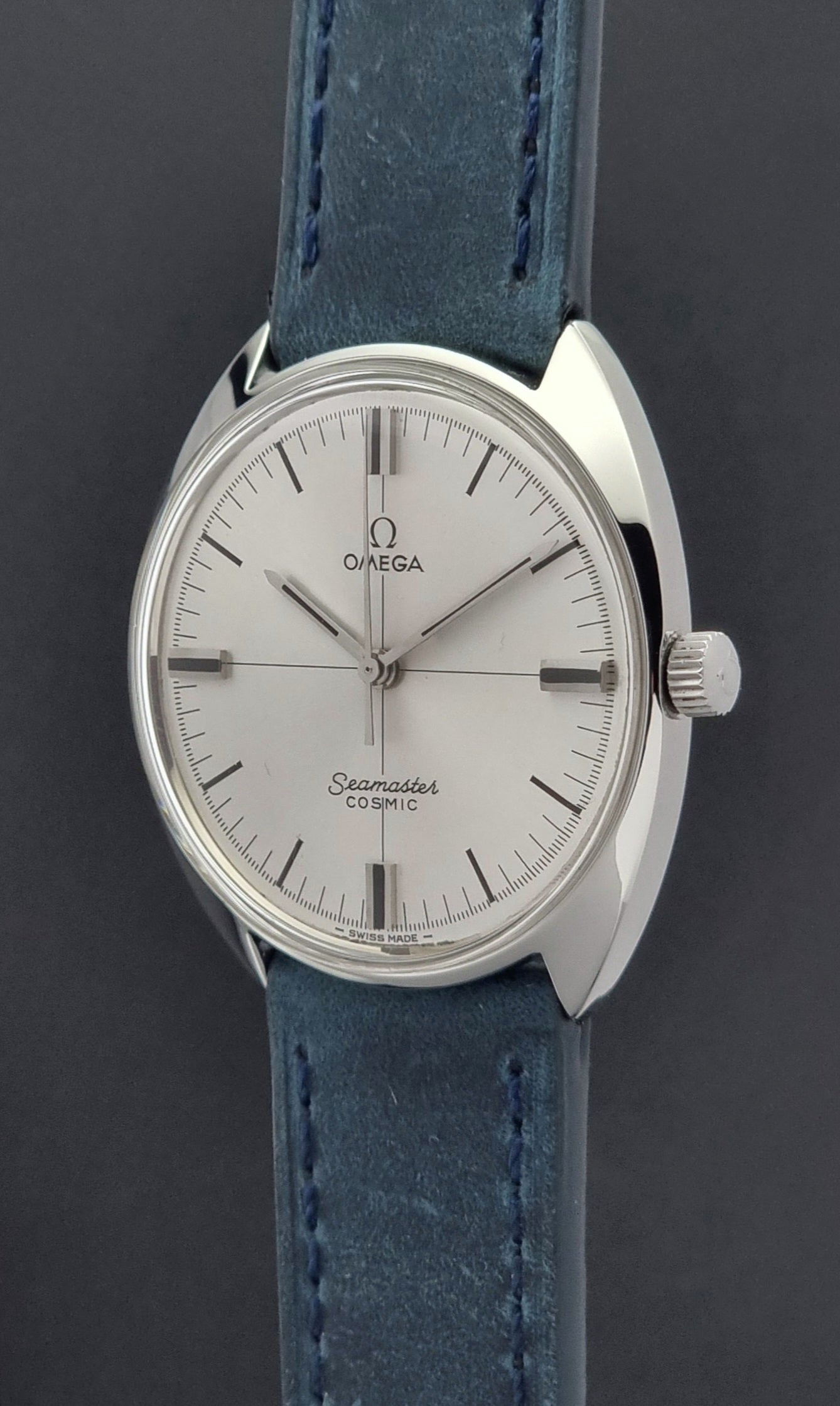 Vintage Omega Wristwatch Seamaster Cosmic 135.017 with blue leather strap on a gray background crown profile view