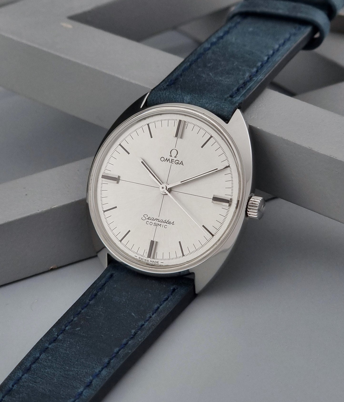 Vintage Omega Wristwatch Seamaster Cosmic 135.017 with blue leather strap on a gray background crown view