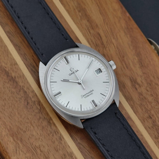 Omega Seamaster Cosmic 136.017 watch with black leather strap on a wooden surface