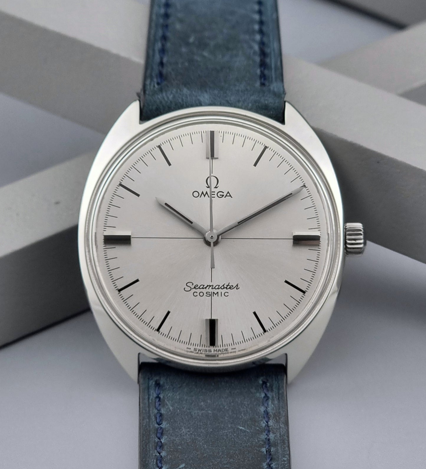 Vintage Omega Wristwatch Seamaster Cosmic 135.017 with blue leather strap on a gray background close up dial