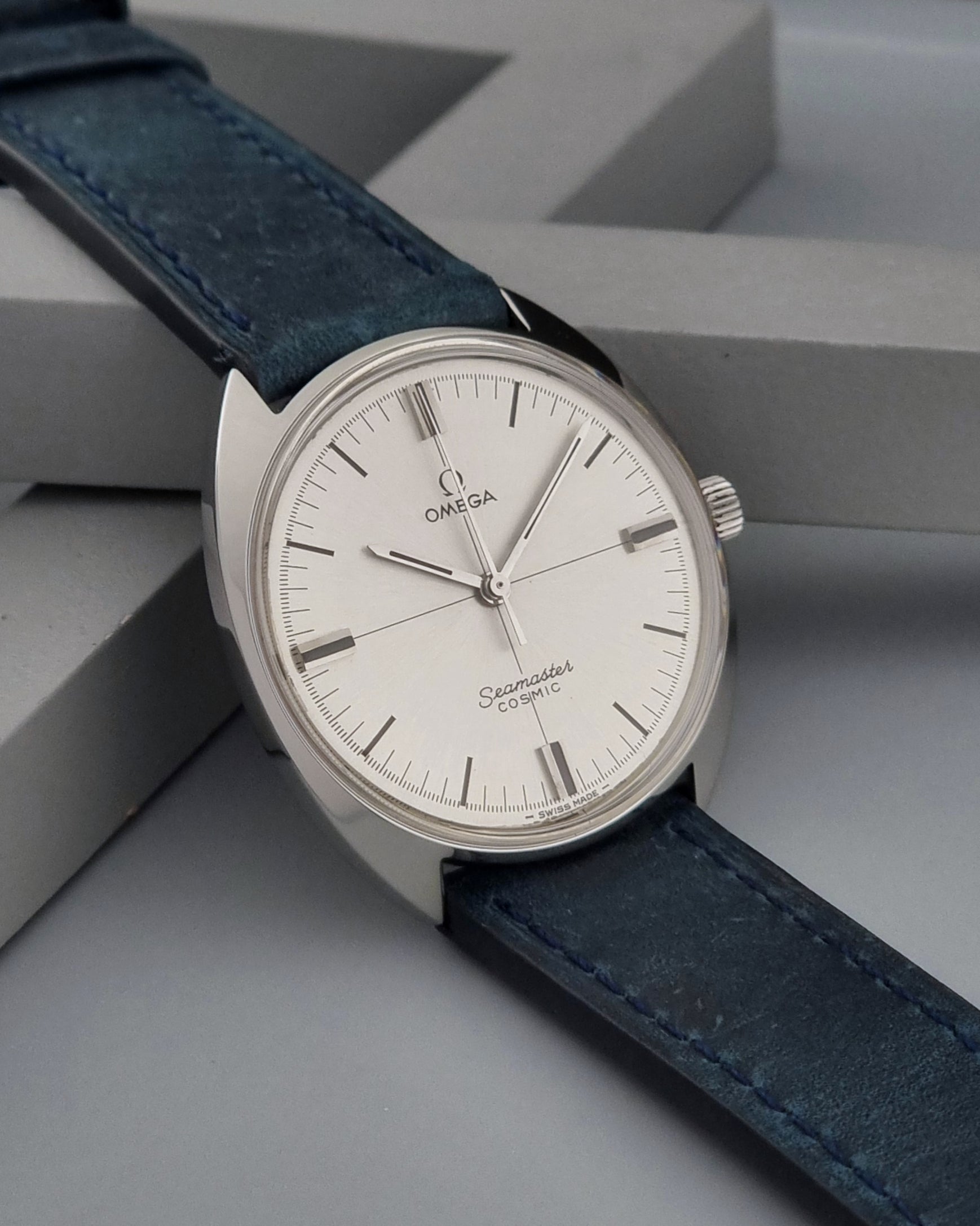 Vintage Omega Wristwatch Seamaster Cosmic 135.017 with blue leather strap on a gray background side view