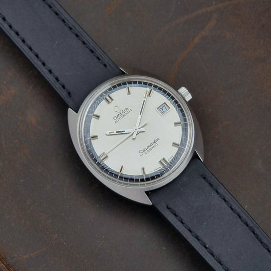 Vintage Omega Seamaster Cosmic watch with black leather strap on a dark surface