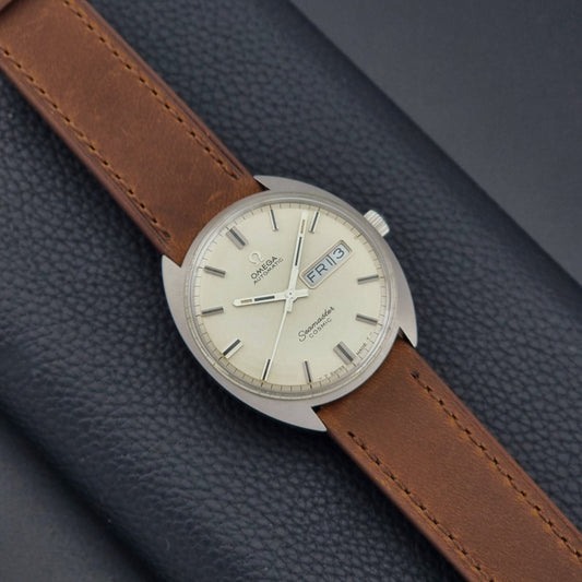Vintage Omega Seamaster Cosmic 166.036 wristwatch with brown leather strap on a dark background front