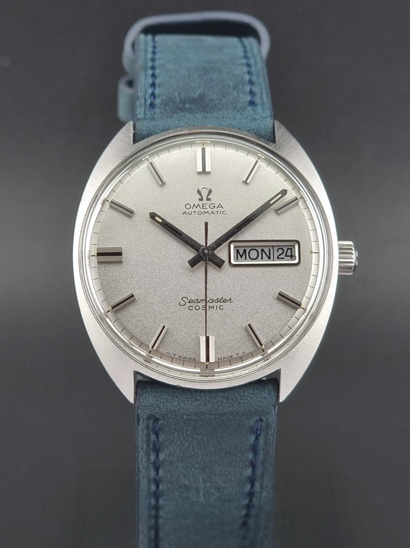 Vintage Omega Seamaster Cosmic watch with blue strap on a dark background