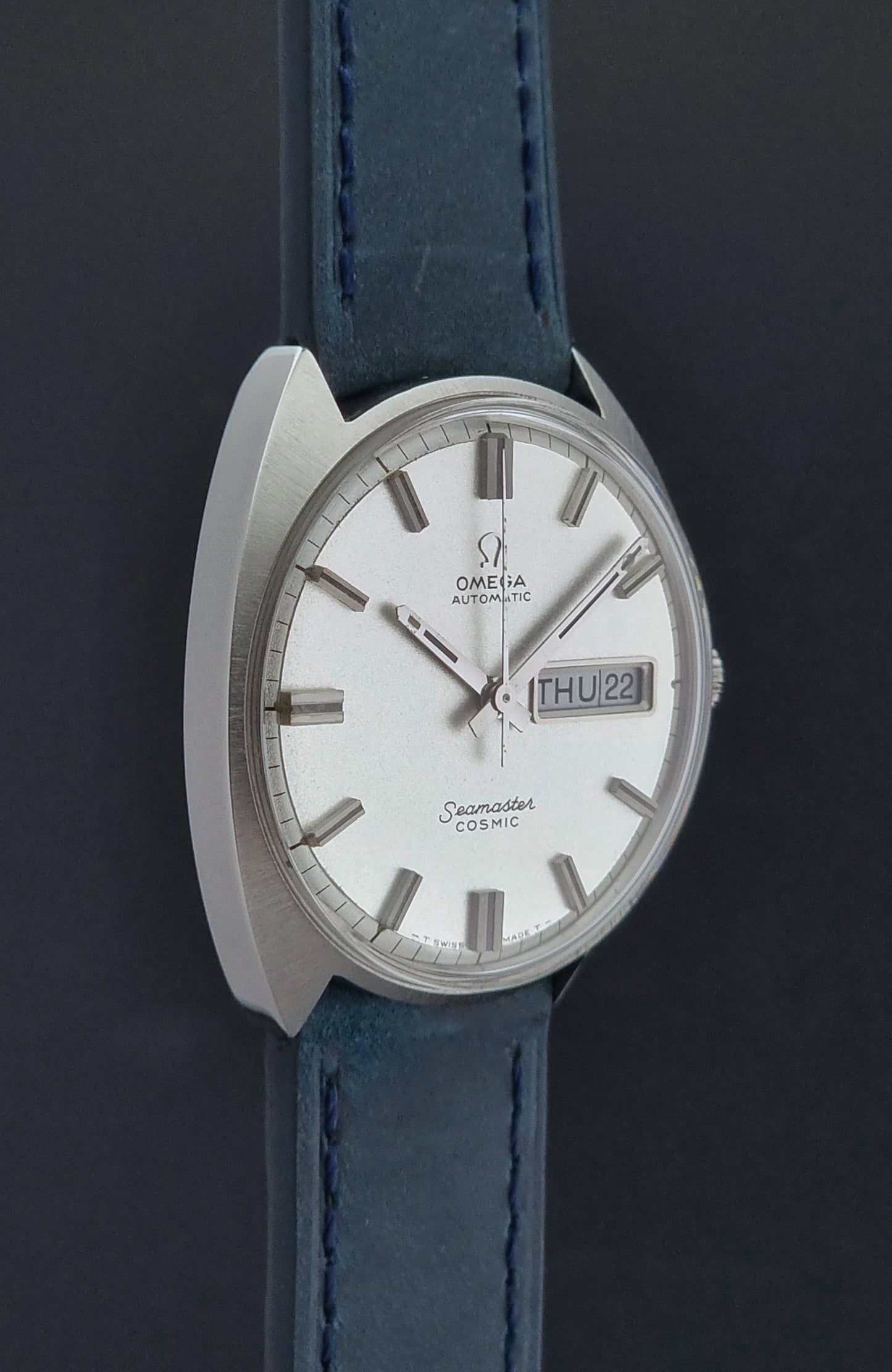 Vintage Omega Wristwatch 166.036 Seamaster Cosmic with blue leather strap on a dark surface side profile view