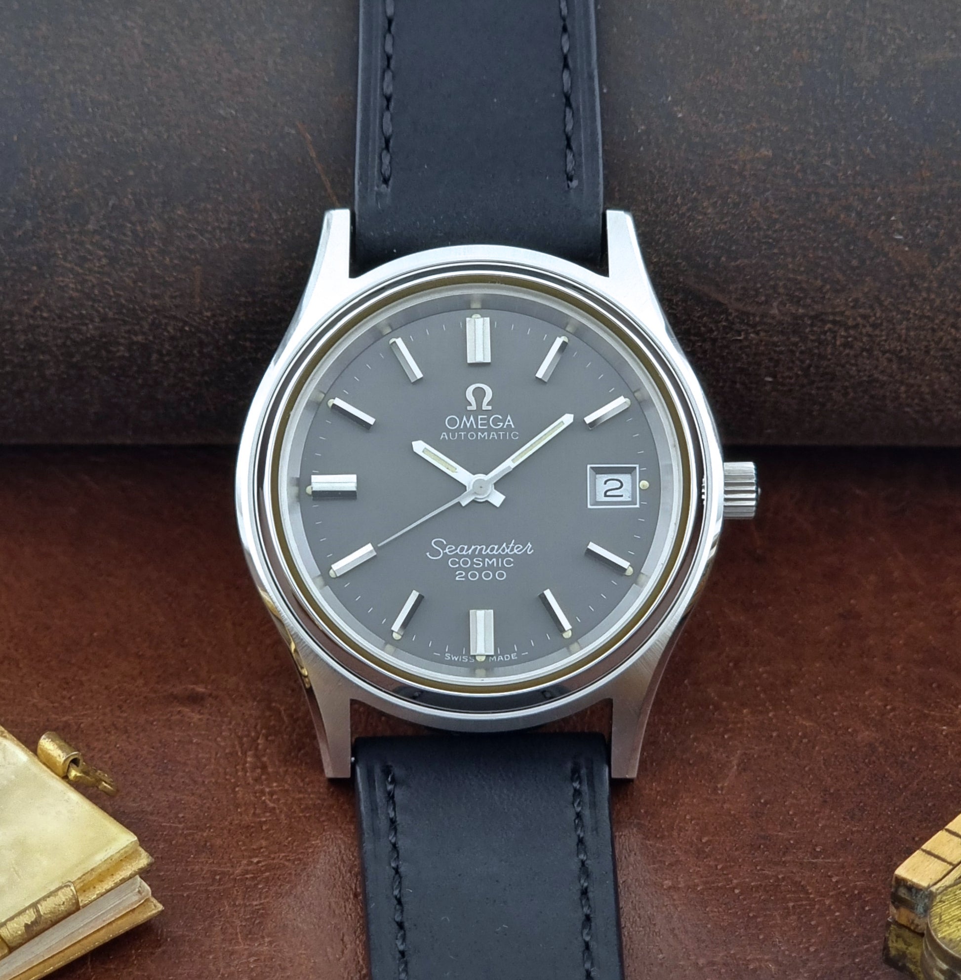 Vintage Omega Wristwatch Seamaster Cosmic 2000 Jumbo 166.128 black leather strap on a brown leather surface front view