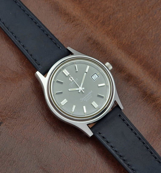 Vintage Omega Wristwatch Seamaster Cosmic 2000 Jumbo 166.128 black leather strap on a brown leather surface front