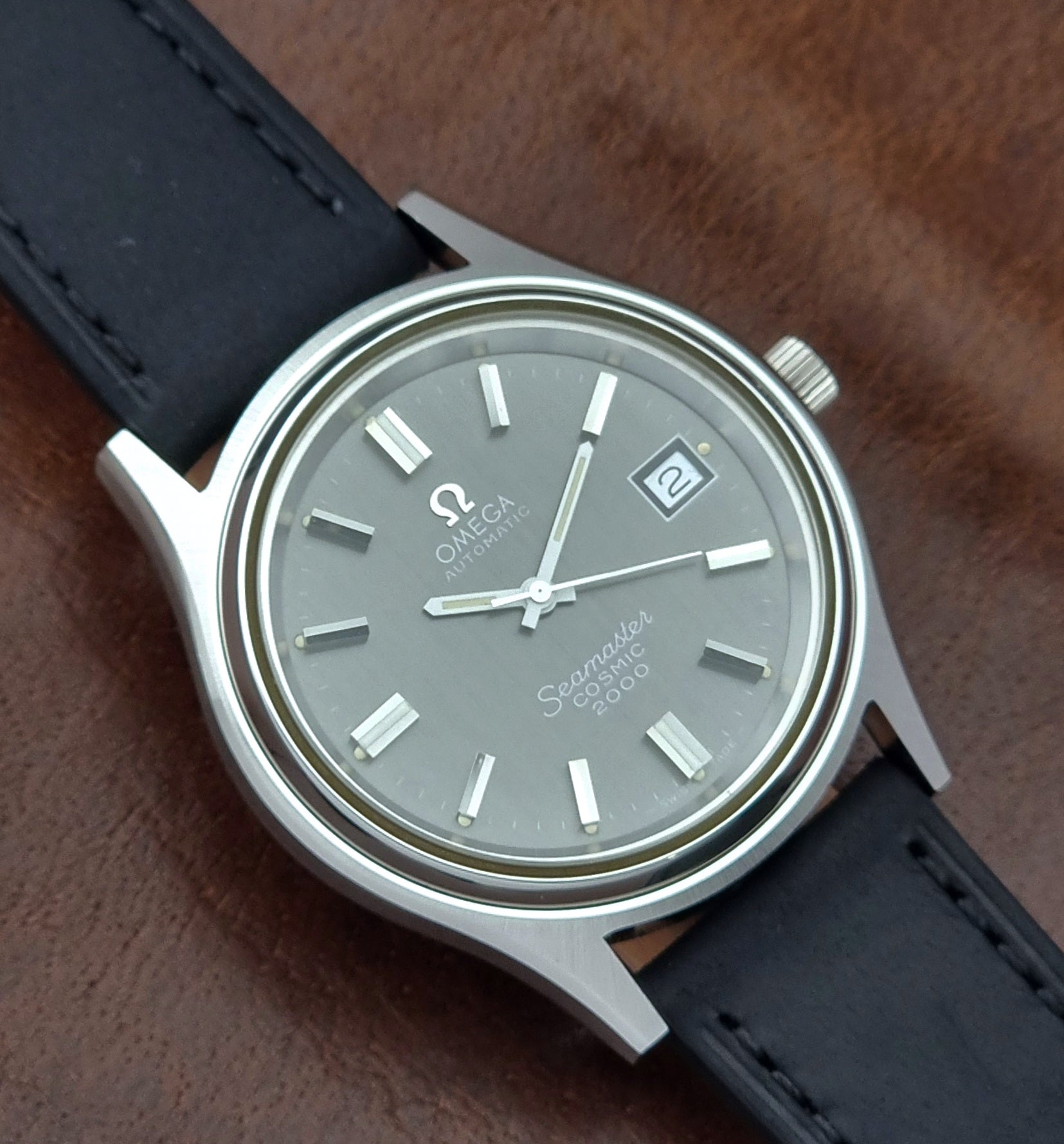 Vintage Omega Wristwatch Seamaster Cosmic 2000 Jumbo 166.128 black leather strap on a brown leather surface close dial view