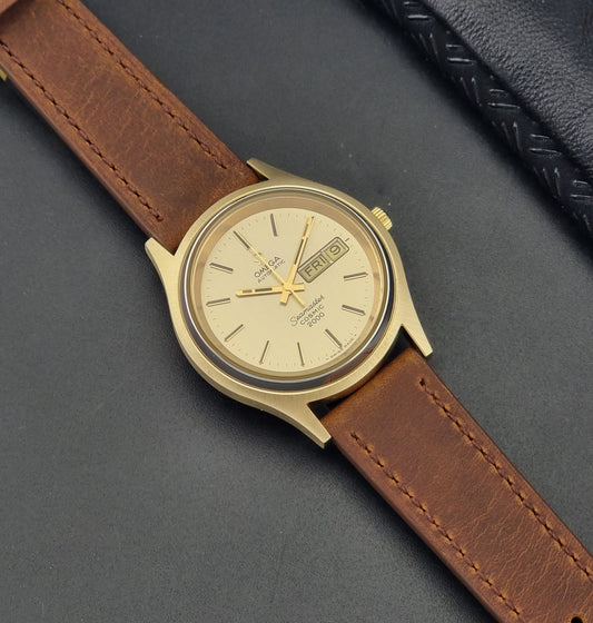 Vintage Omega Wristwatch Seamaster Cosmic 2000 Jumbo 166.129 watch with brown leather strap on a gray surface dial