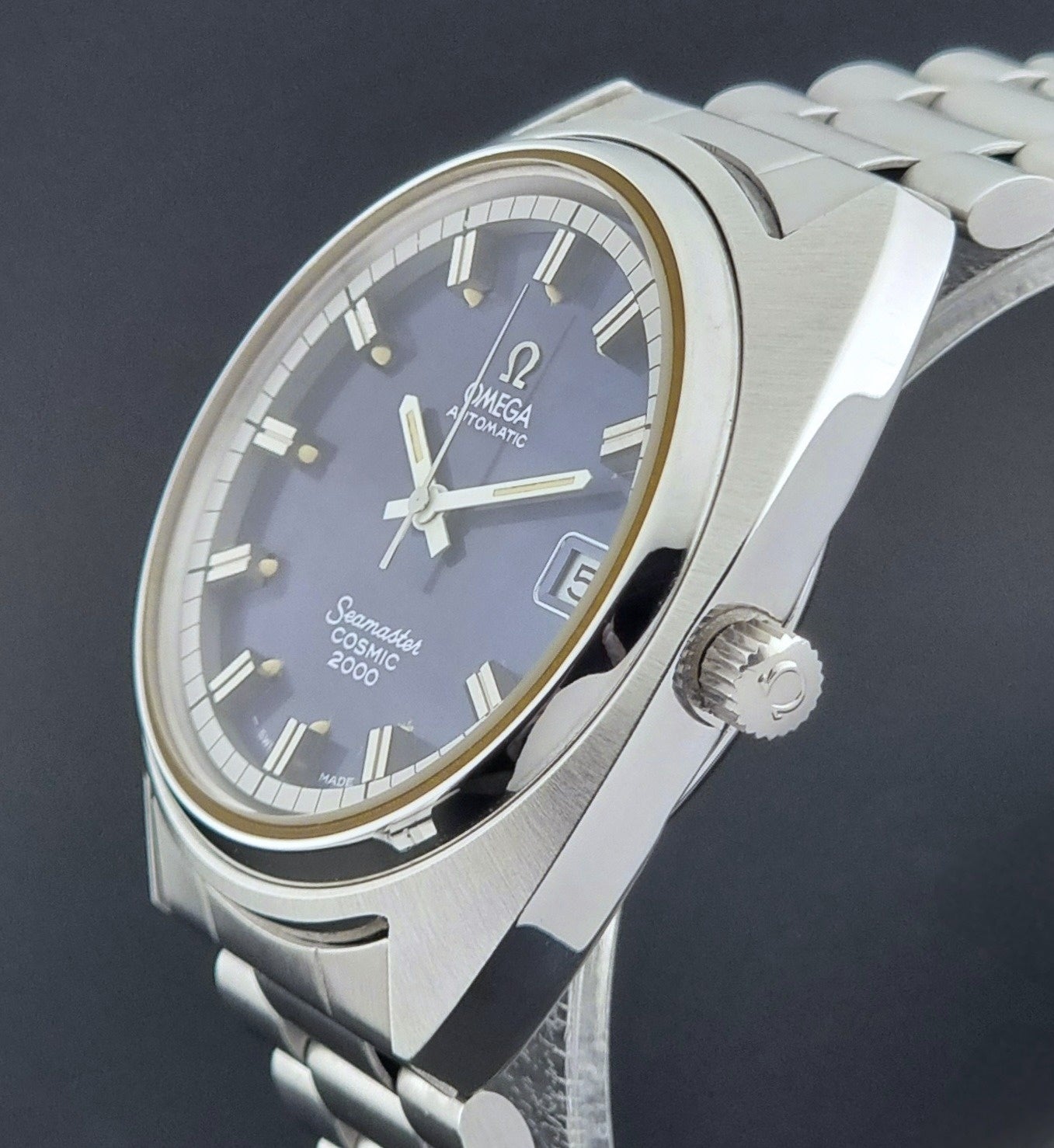 Vintage Omega Wristwatch Seamaster Cosmic 2000 Jumbo 166.130 watch with  stainless steel bracelet on a dark background close crown profile view