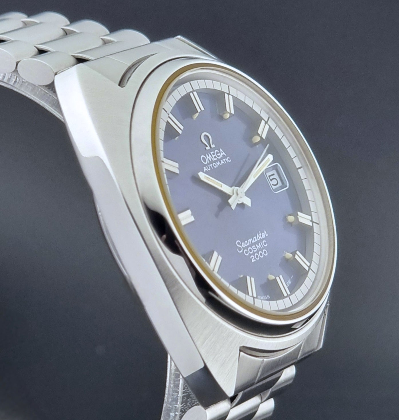 Vintage Omega Wristwatch Seamaster Cosmic 2000 Jumbo 166.130 watch with  stainless steel bracelet on a dark background close side profile