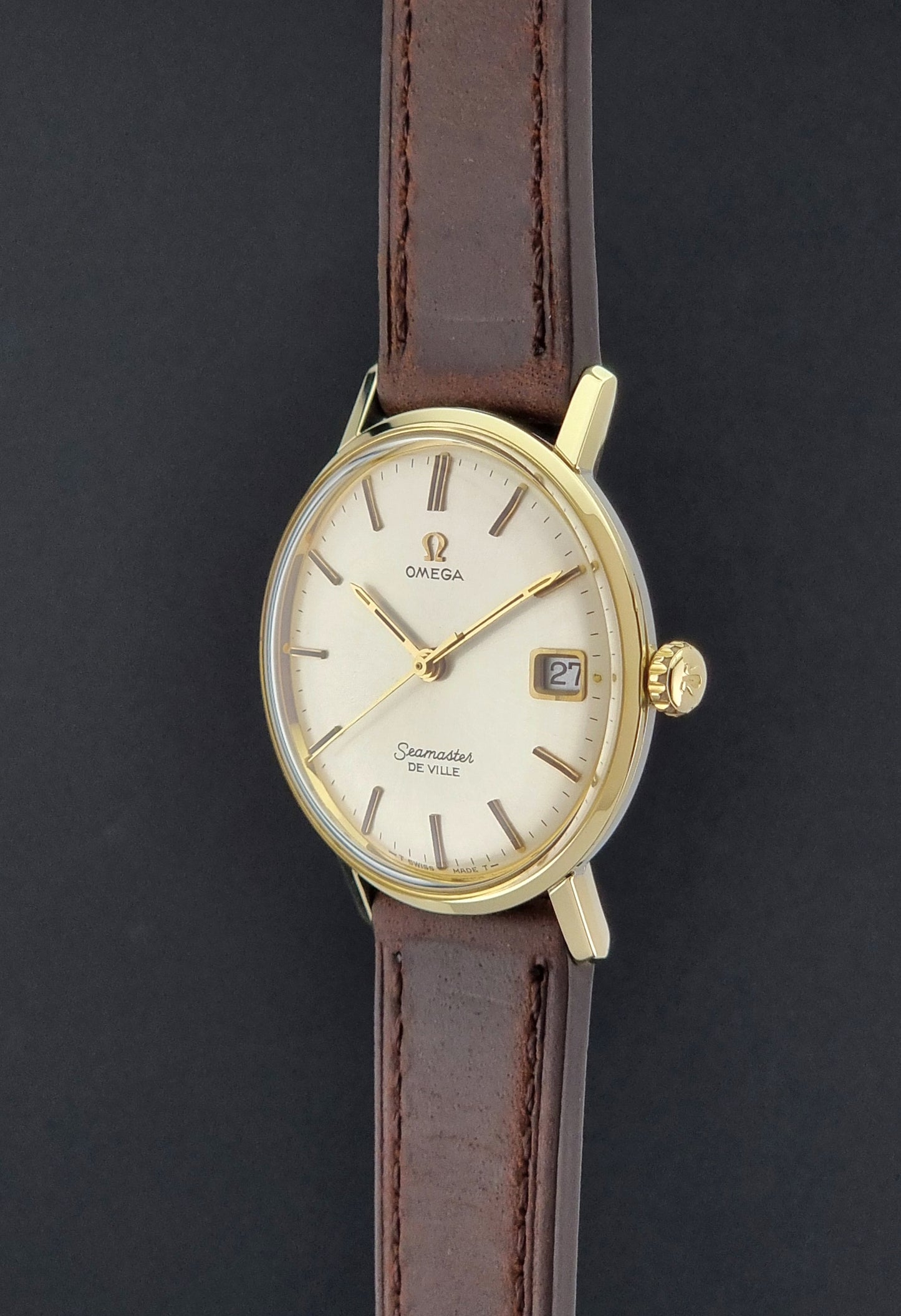 Vintage Omega Wristwatch Seamaster De-ville 136.020 gold capped with brown strap on a dark background crown profie view