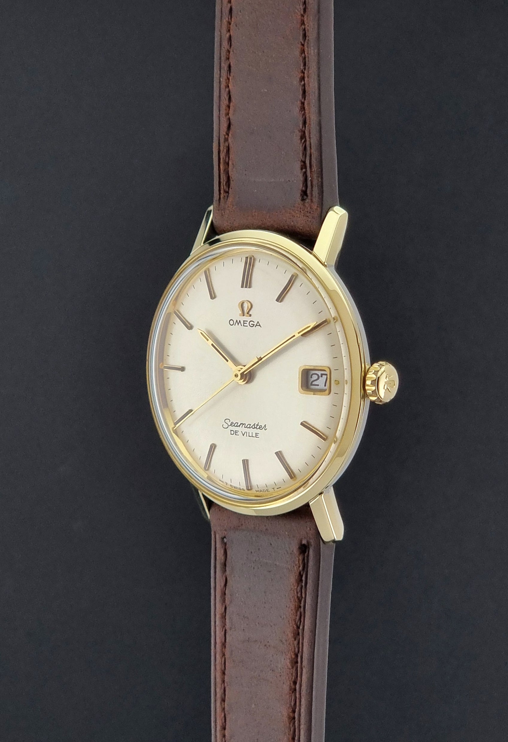 Vintage Omega Wristwatch Seamaster De-ville 136.020 gold capped with brown strap on a dark background crown profie view