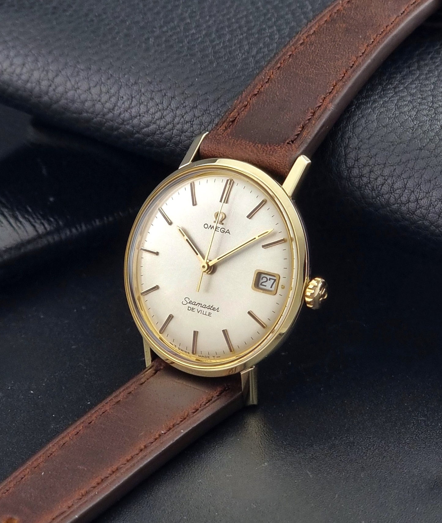 Vintage Omega Wristwatch Seamaster De-ville 136.020 gold capped with brown strap on a dark background crown view