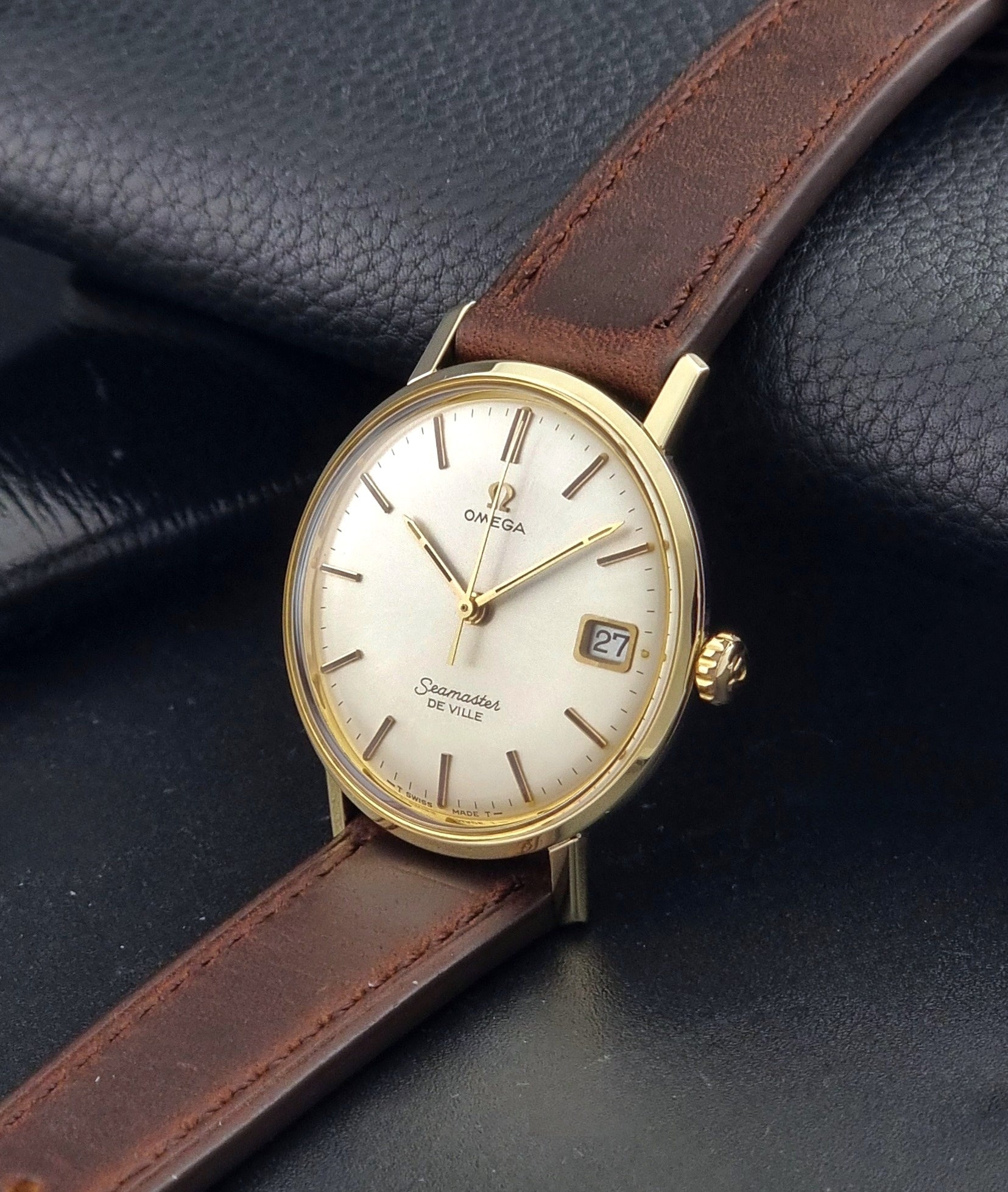 Vintage Omega Wristwatch Seamaster De-ville 136.020 gold capped with brown strap on a dark background crown view