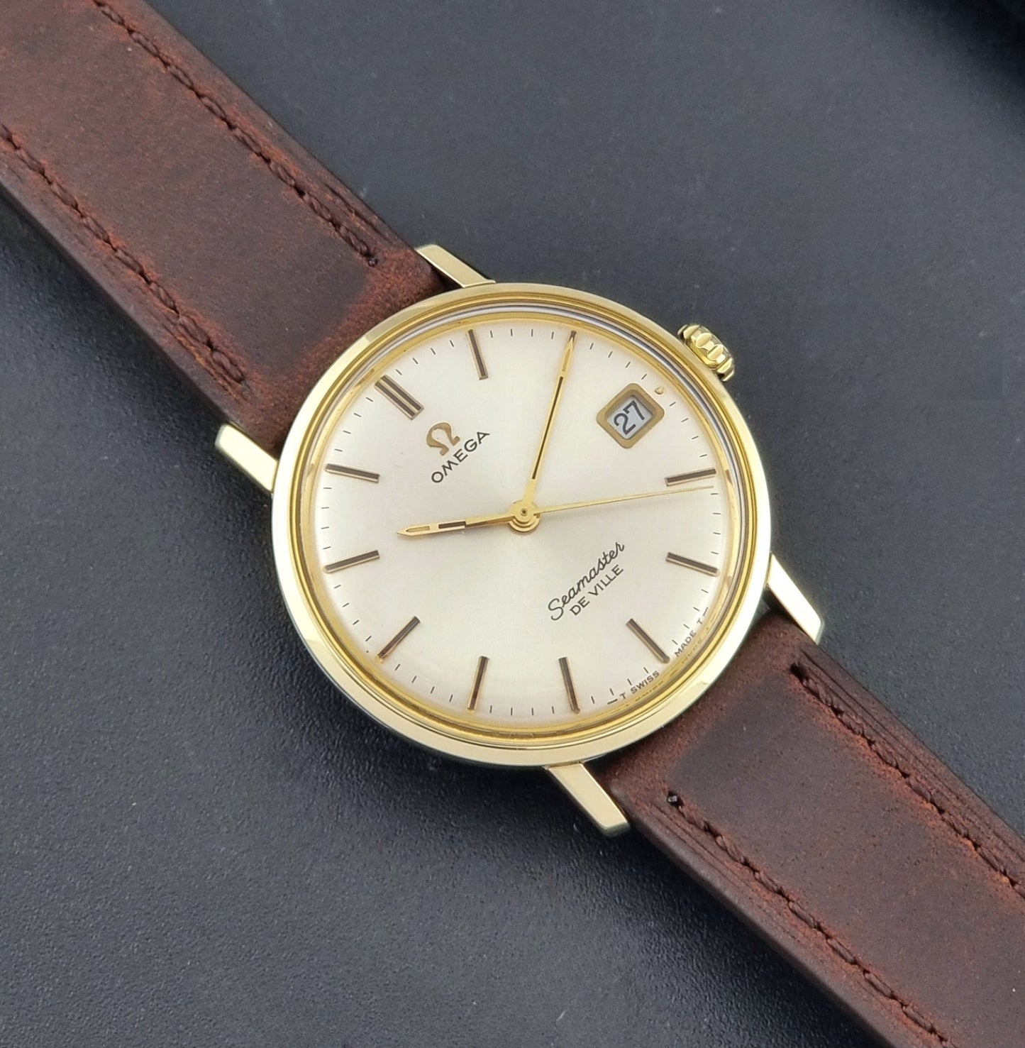 Vintage Omega Wristwatch Seamaster De-ville 136.020 gold capped with brown strap on a dark background close up dial view