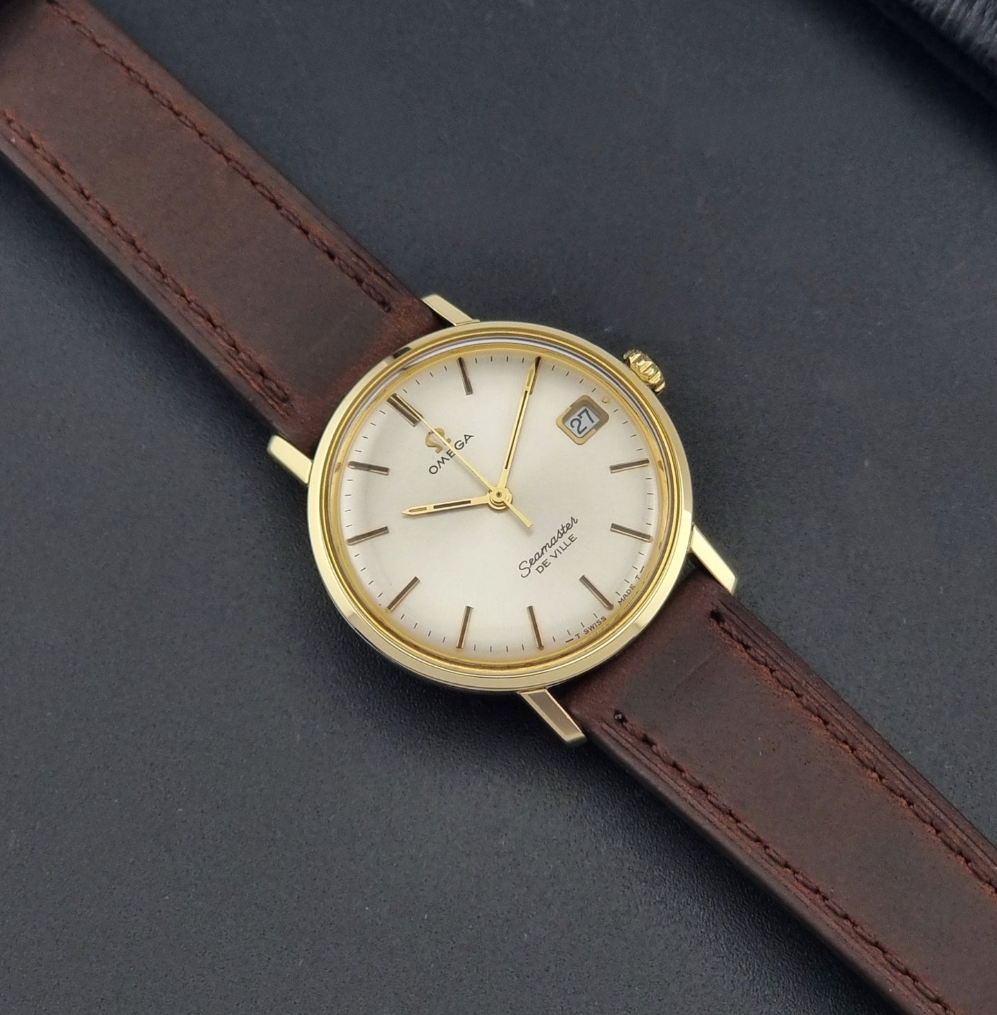 Vintage Omega Wristwatch Seamaster De-ville 136.020 gold capped with brown strap on a dark background dial
