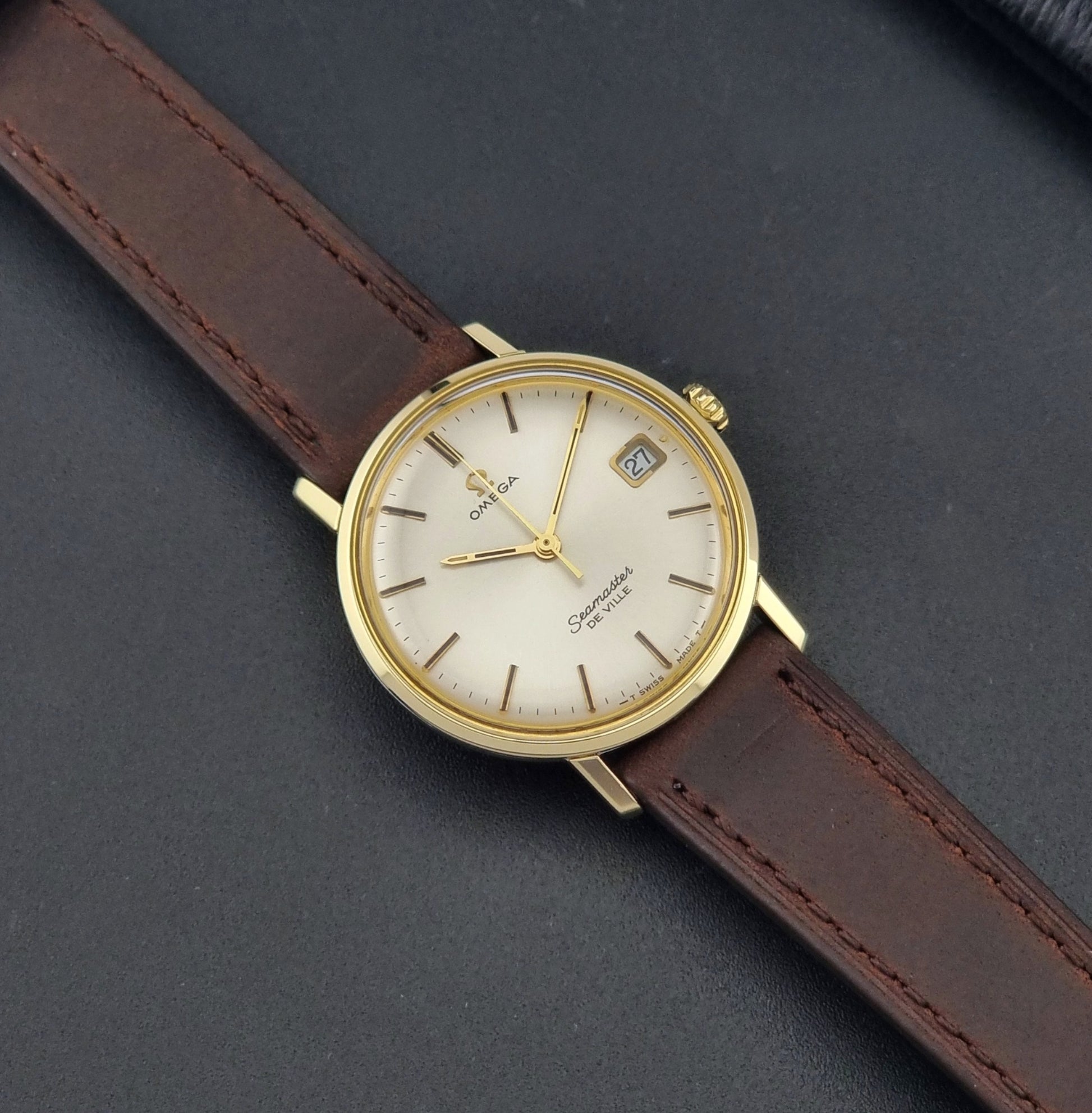 Vintage Omega Wristwatch Seamaster De-ville 136.020 gold capped with brown strap on a dark background dial