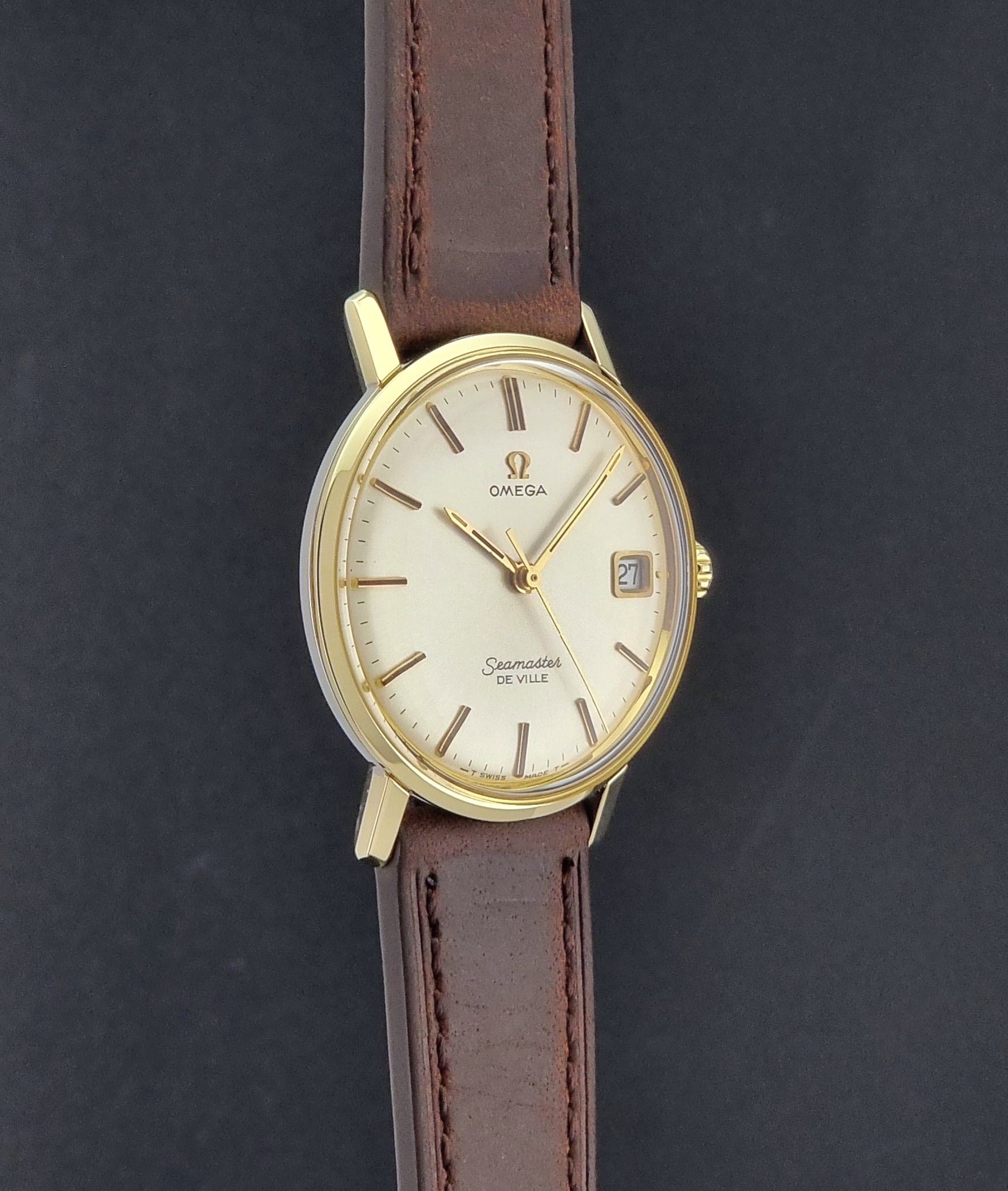 Vintage Omega Wristwatch Seamaster De-ville 136.020 gold capped with brown strap on a dark background side profile view