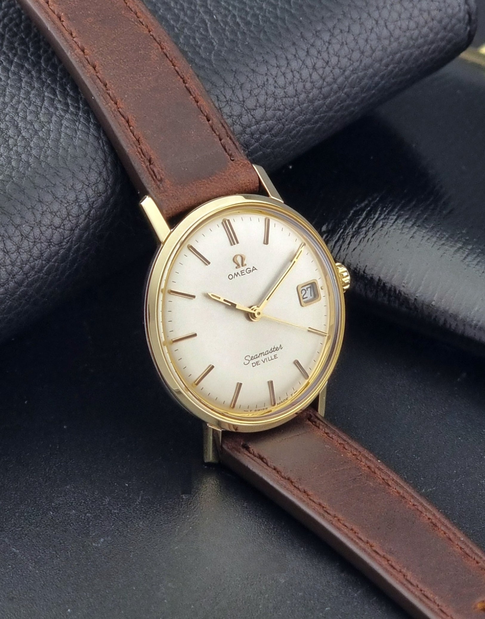 Vintage Omega Wristwatch Seamaster De-ville 136.020 gold capped with brown strap on a dark background side view