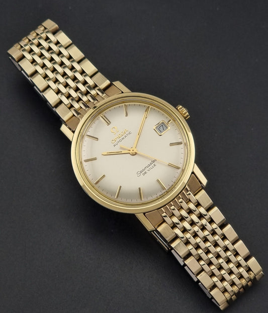 Vintage Omega Wristwatch Seamaster De-ville 166.020 with gold omega bracelet, gold case, on a dark gray background dial