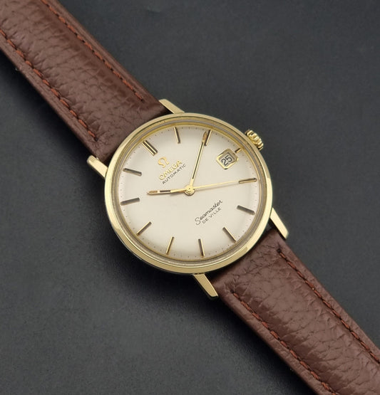 Vintage Omega Wristwatch Seamaster De-ville 166.020 with a brown textured leather strap, gold case, on a dark gray background dial