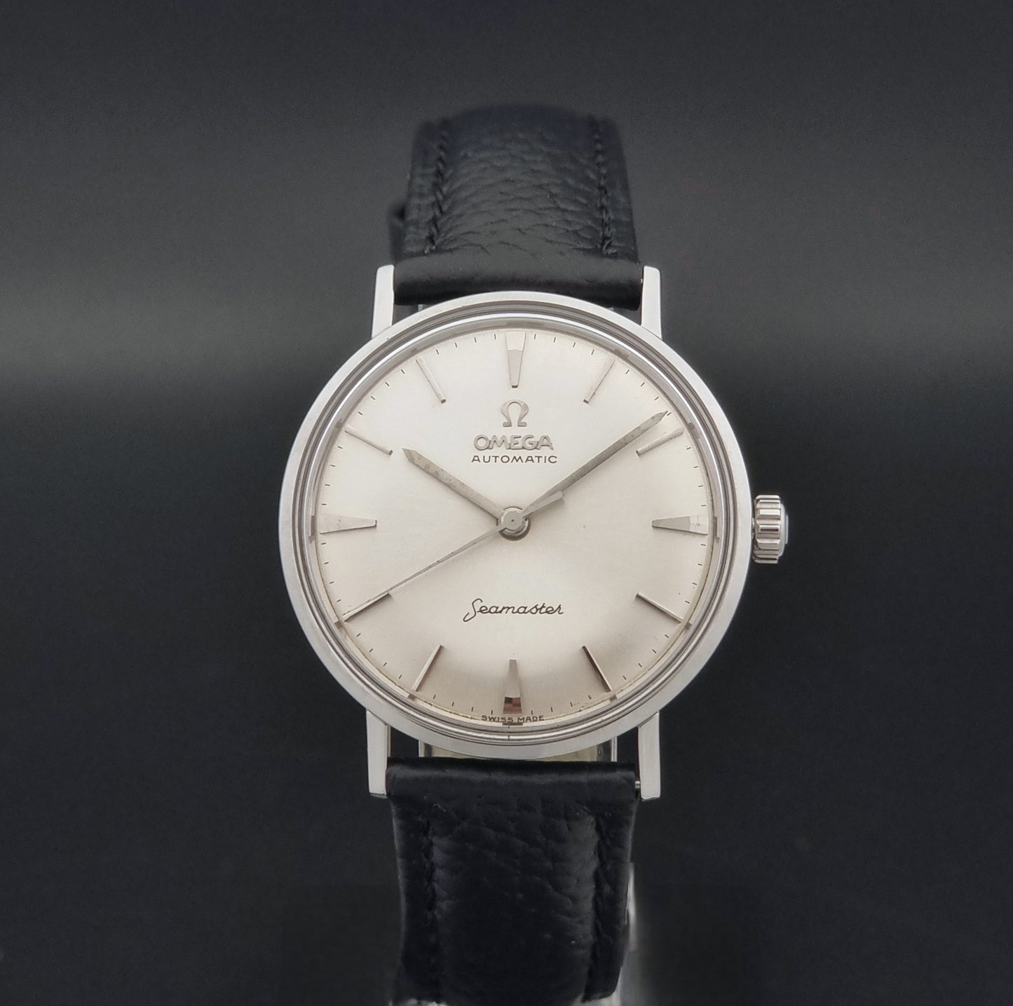 Vintage Omega Seamaster 14765 Wristwatch on a texture black leather strap on a dark background close dial view