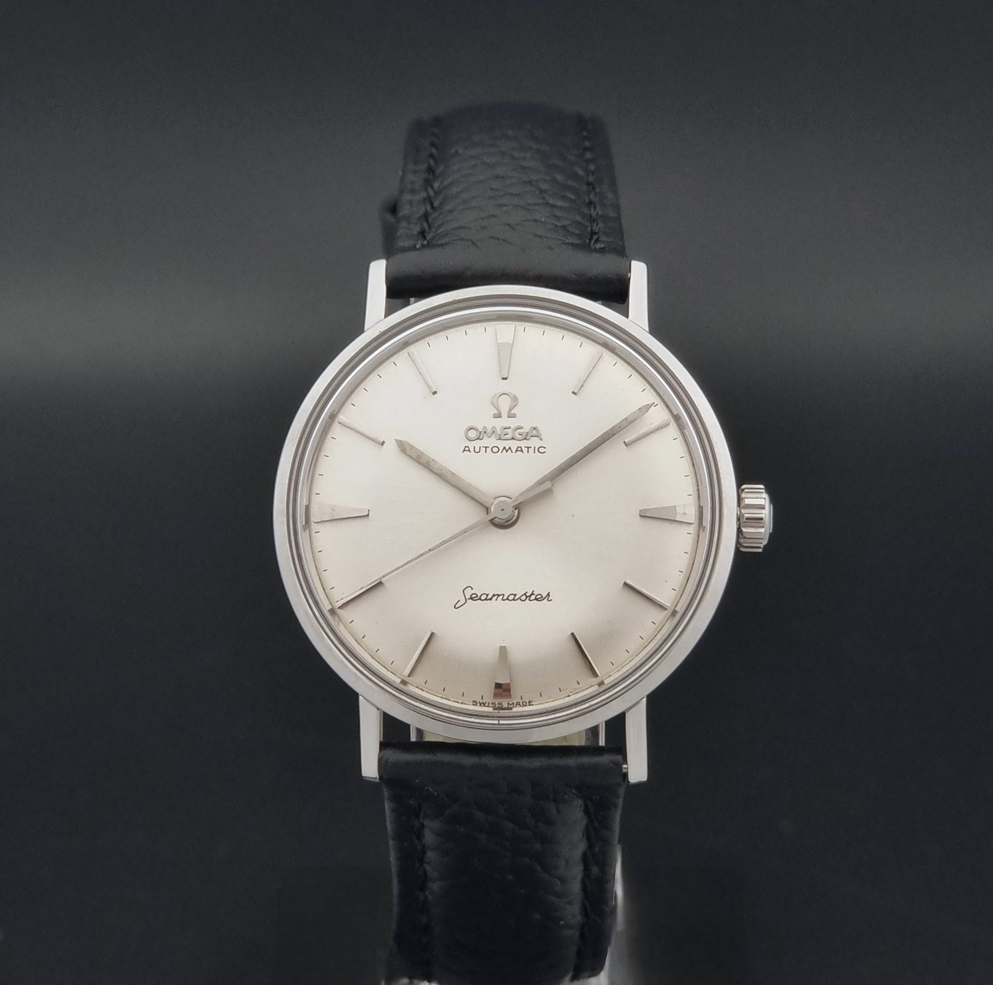 Vintage Omega Seamaster 14765 Wristwatch on a texture black leather strap on a dark background close dial view