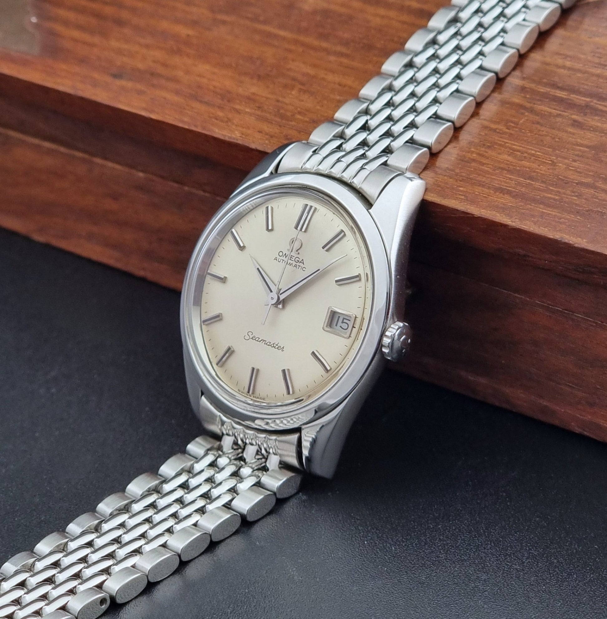 Vintage Omega Wristwatch Seamaster 166.010 with a detailed face on a dark background crown view