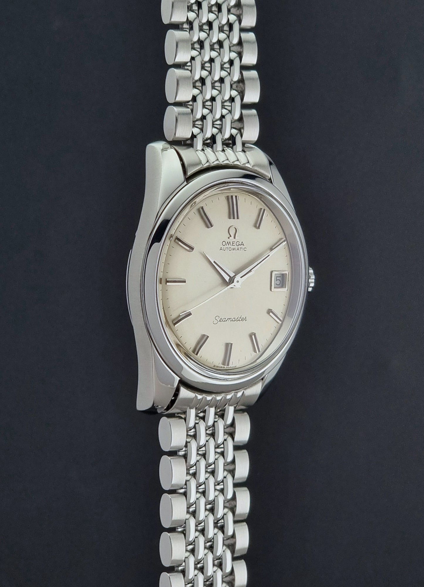 Vintage Omega Wristwatch Seamaster 166.010 with a detailed face on a dark background crown profile view