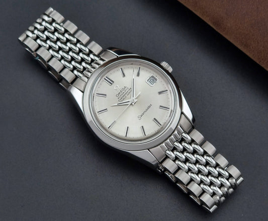 Vintage Omega Wristwatch Seamaster 166.010 on a stainless steel bracelet on a dark surface front