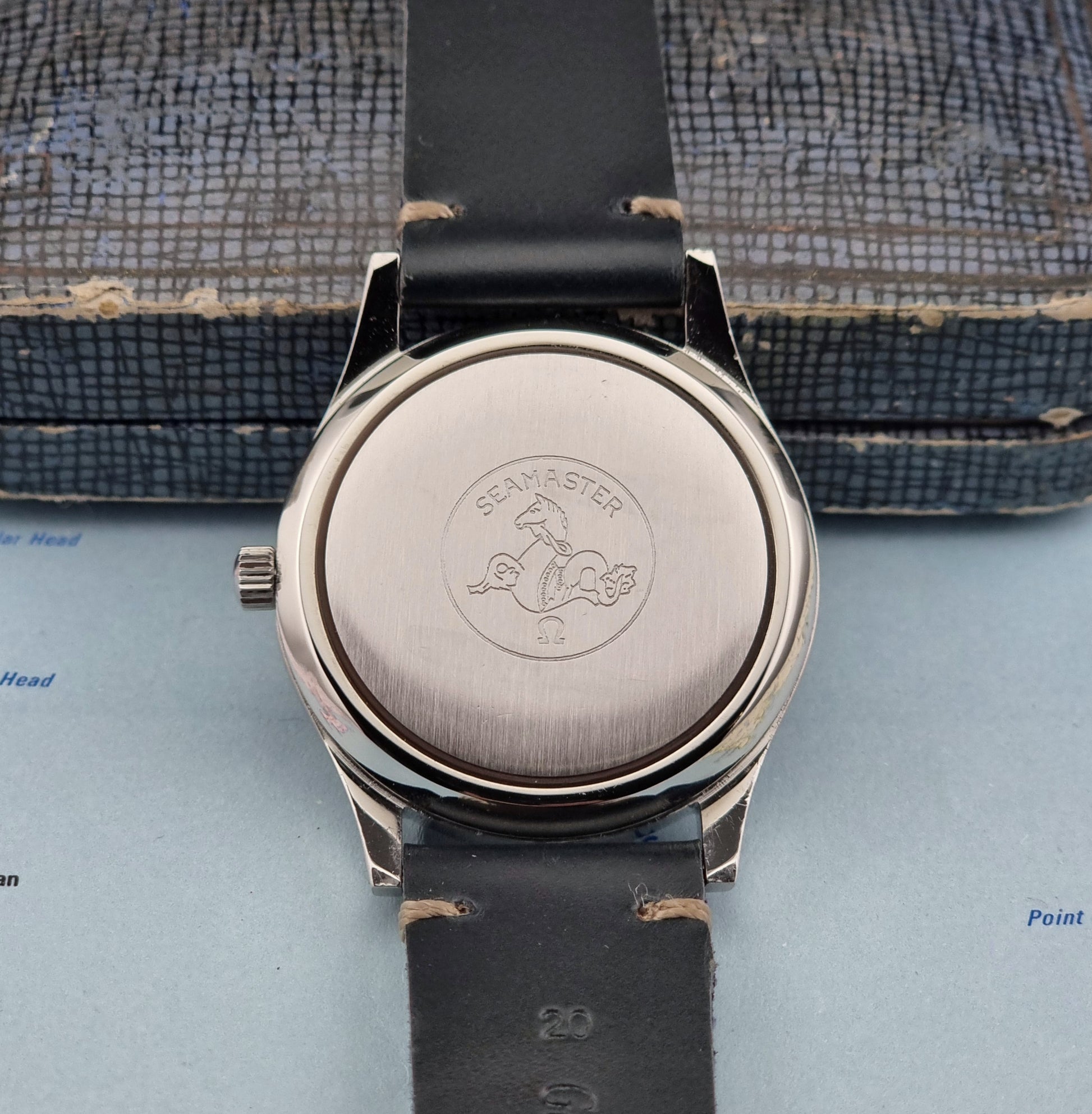 Omega Seamaster Cosmic 2000 166.128case back logo on a textured surface