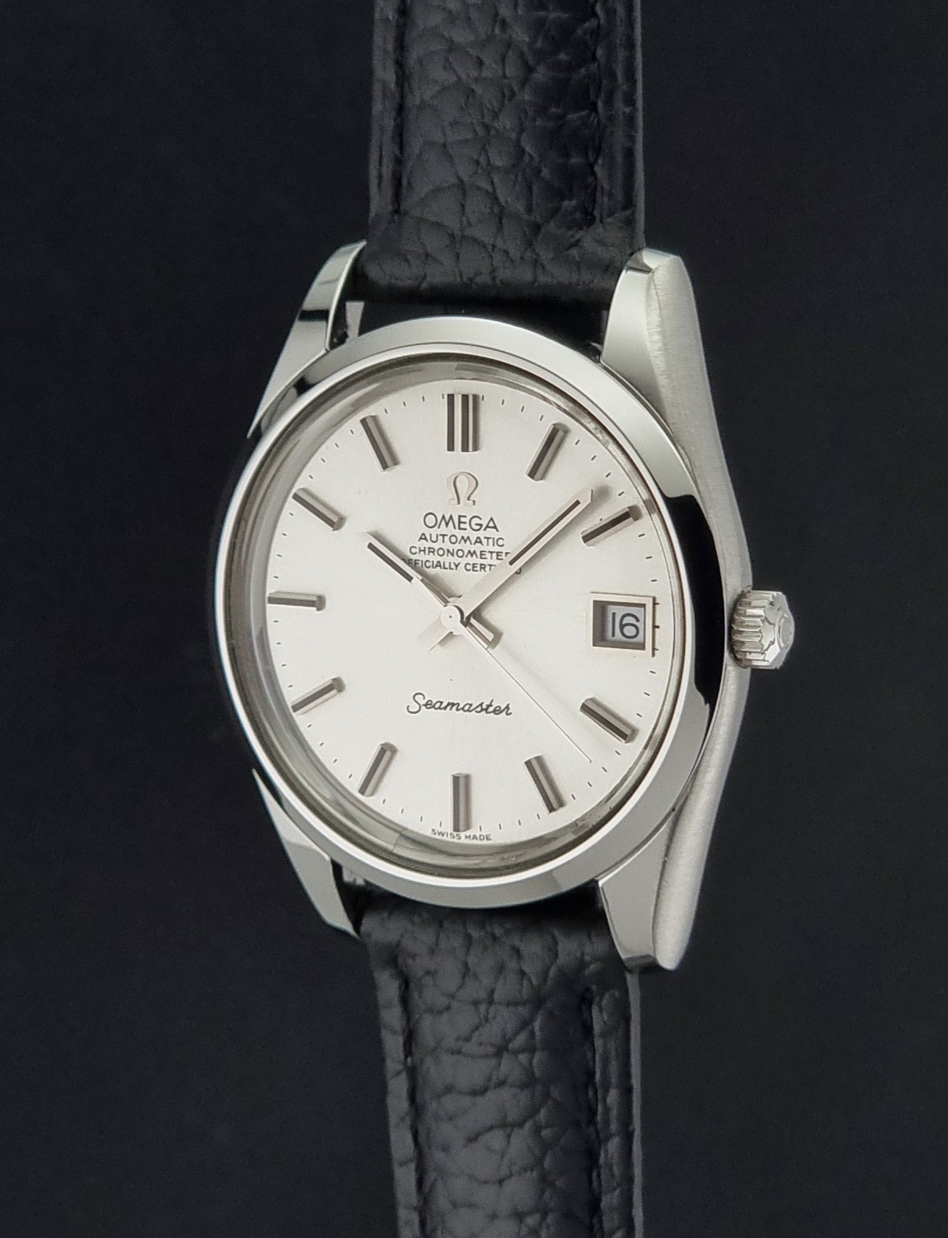 Vintage Omega Seamaster 168.0061/166.0172 with a silver stainless steel case and a textured black leather strap, shown on a dark background crown profile view