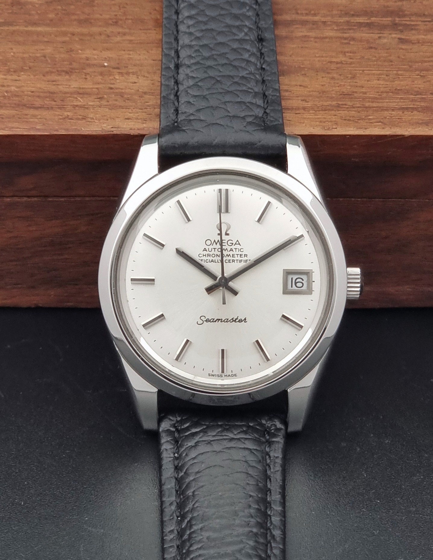 Vintage Omega Seamaster 168.0061/166.0172 with a silver stainless steel case and a textured black leather strap, shown on a dark background dial view