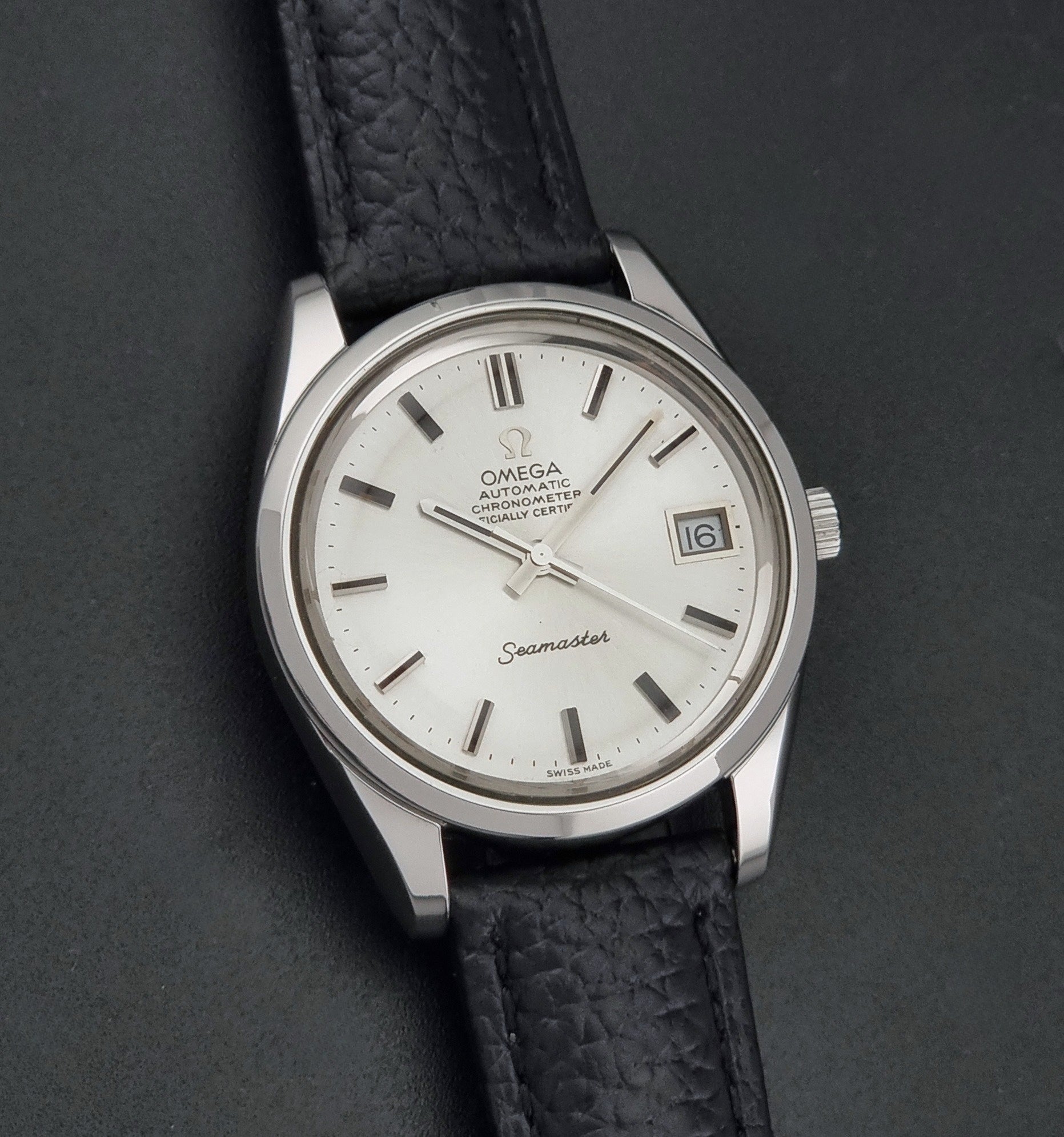 Vintage Omega Seamaster 168.0061/166.0172 with a silver stainless steel case and a textured black leather strap, shown on a dark background front view