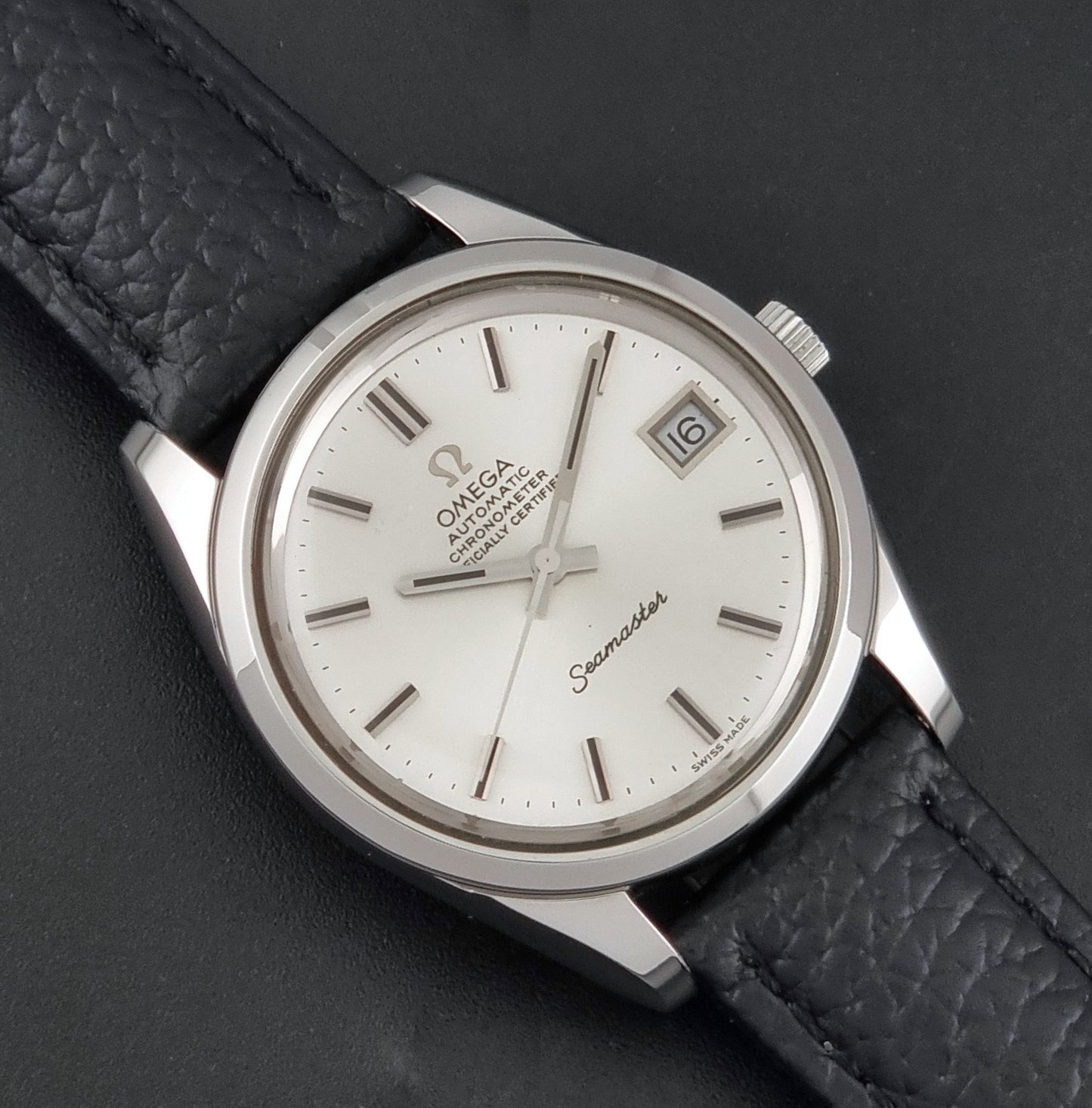 Vintage Omega Seamaster 168.0061/166.0172 with a silver stainless steel case and a textured black leather strap, shown on a dark background close up dial view