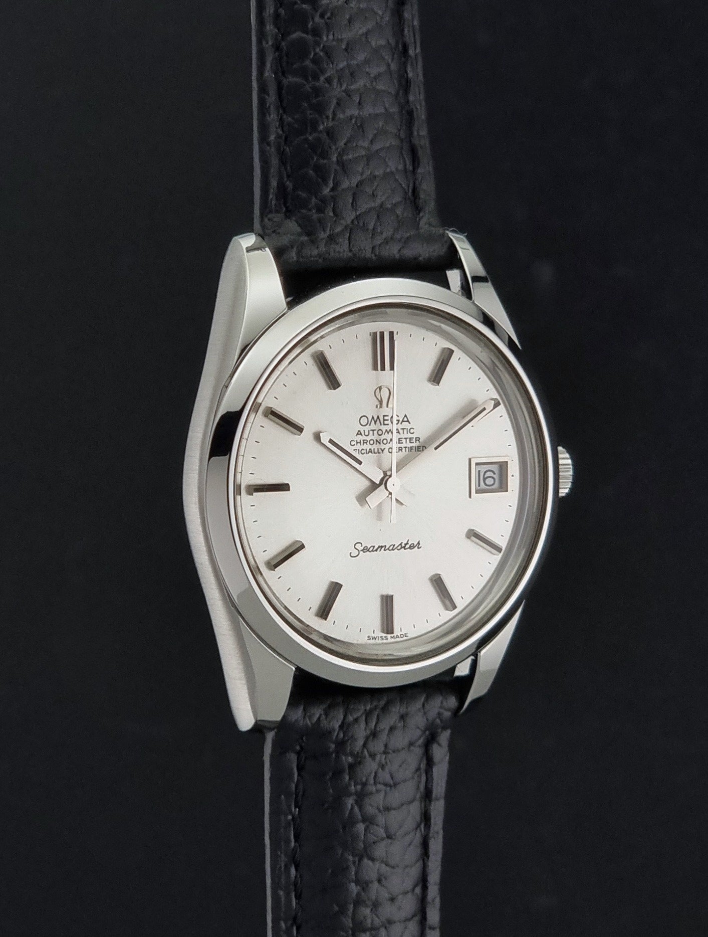 Vintage Omega Seamaster 168.0061/166.0172 with a silver stainless steel case and a textured black leather strap, shown on a dark background side profile view