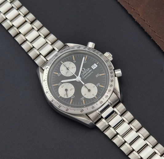 Vintage Omega Speedmaster 3511.50 watch Reverse Panda with a black face on a dark background dial
