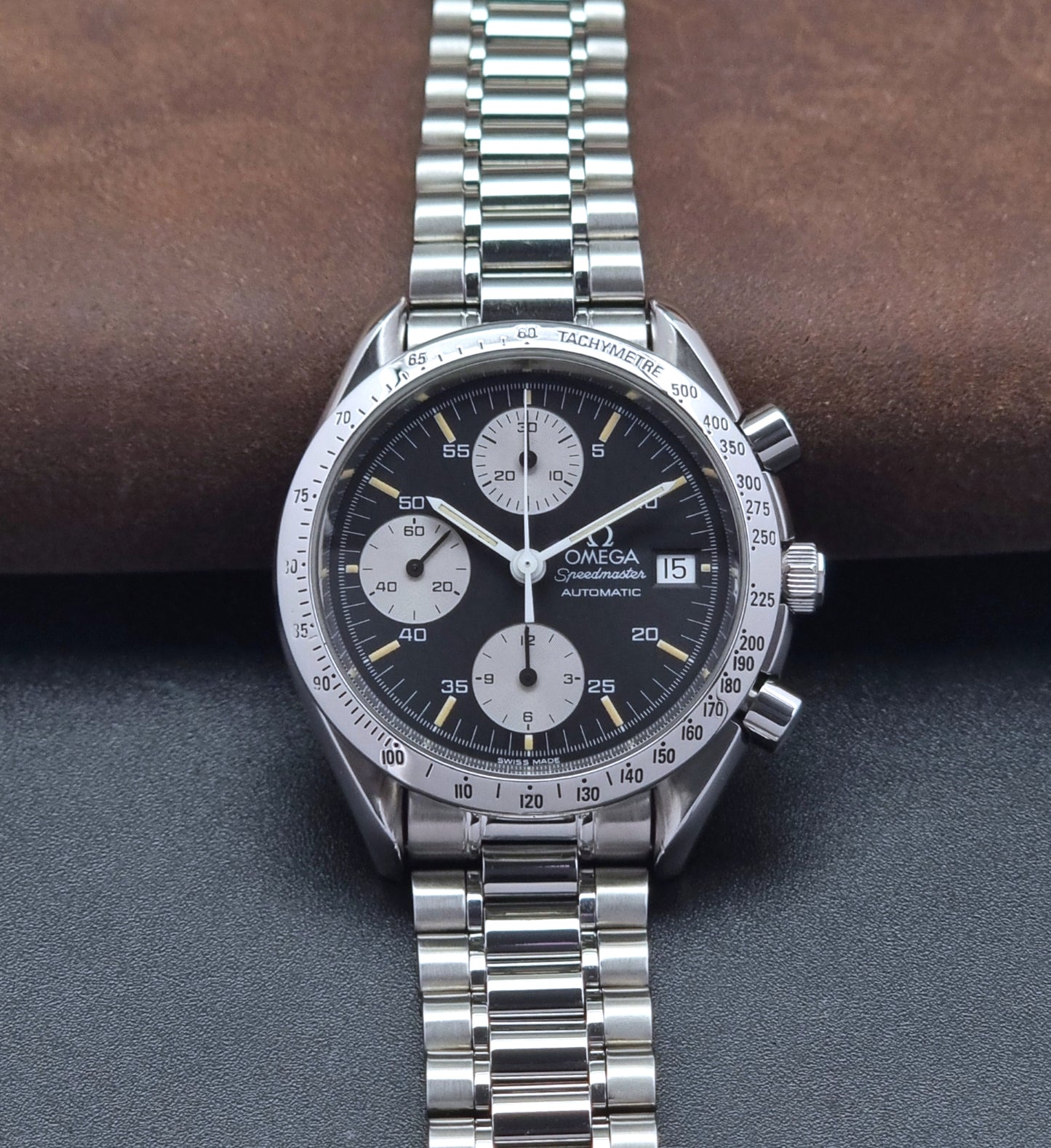 Vintage Omega Speedmaster watch 3511.50  Reverse Panda Date Chronograph with a black face on a dark background front view