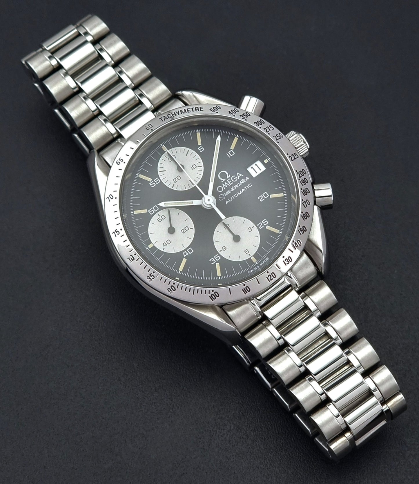 Vintage Omega Speedmaster watch 3511.50  Reverse Panda Date Chronograph with a black face on a dark background white sub dials