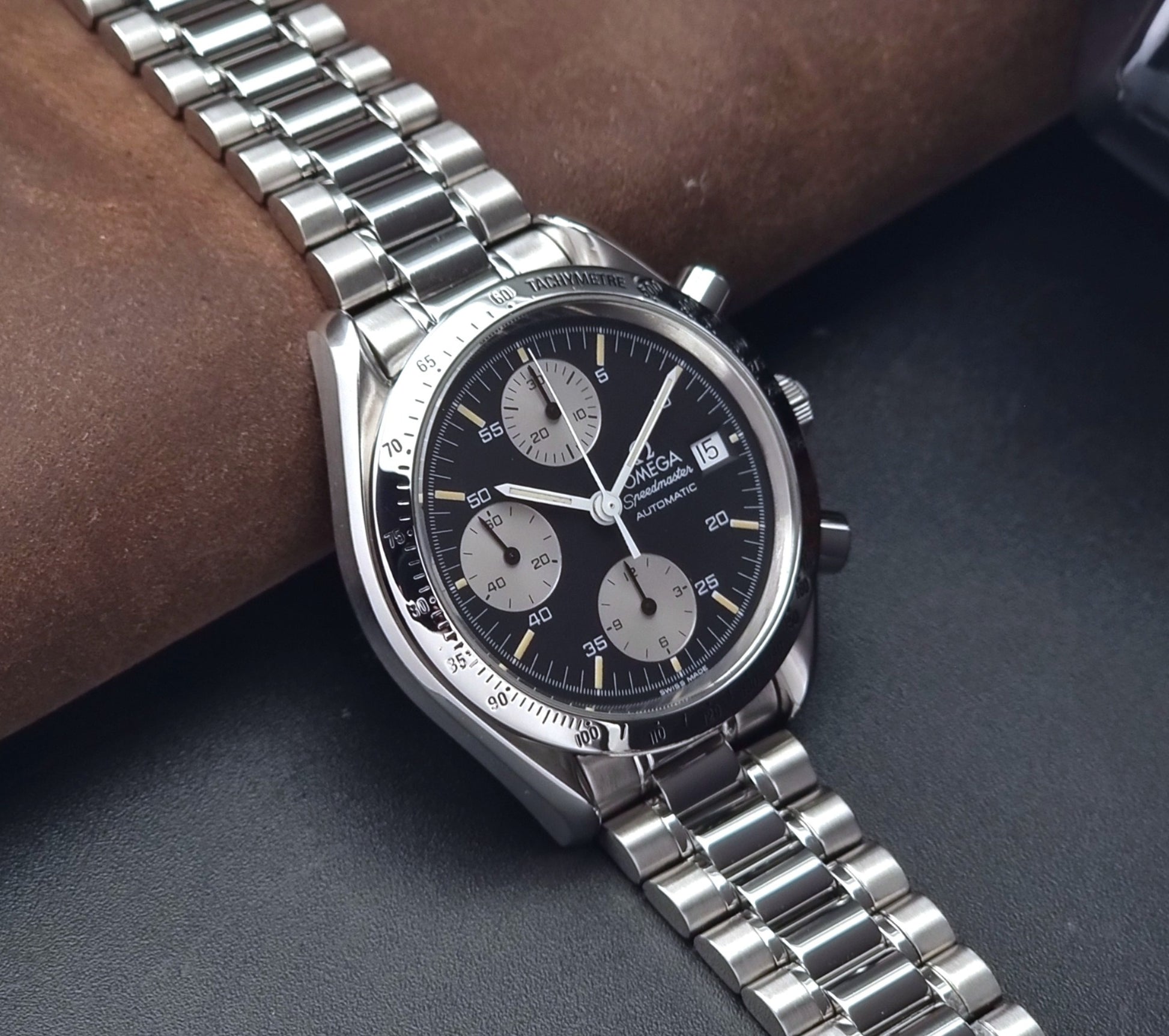 Vintage Omega Speedmaster watch 3511.50  Reverse Panda Date Chronograph with a black face on a dark background side view
