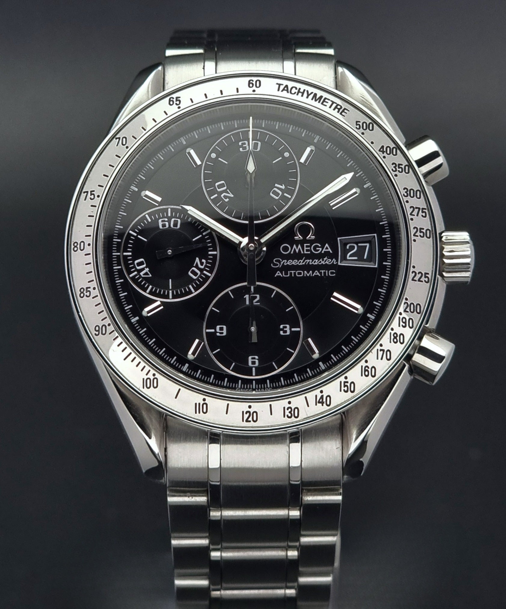 Omega Speedmaster watch with black dial on a dark background