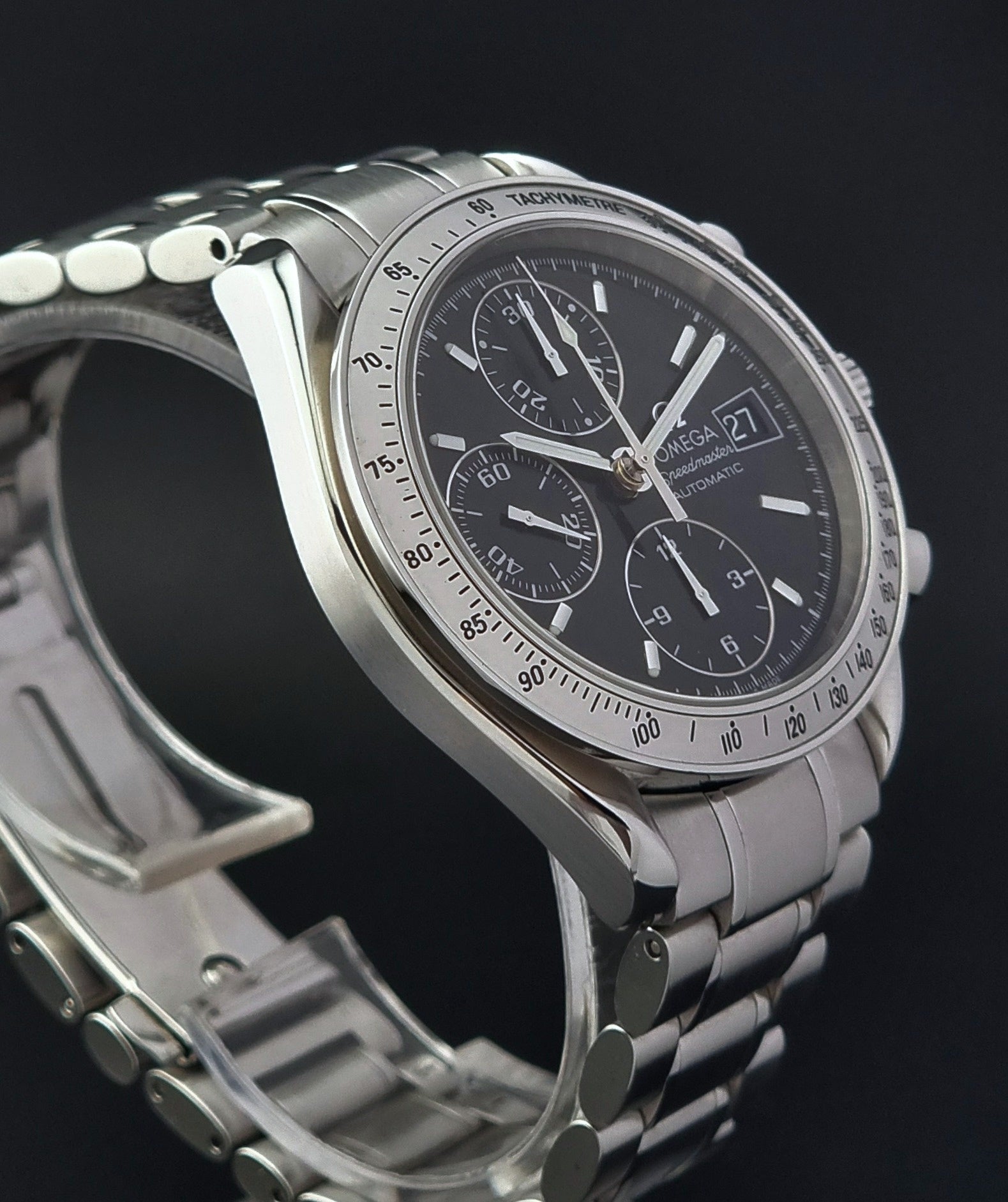 Omega Speedmaster watch with a black face on a dark background
