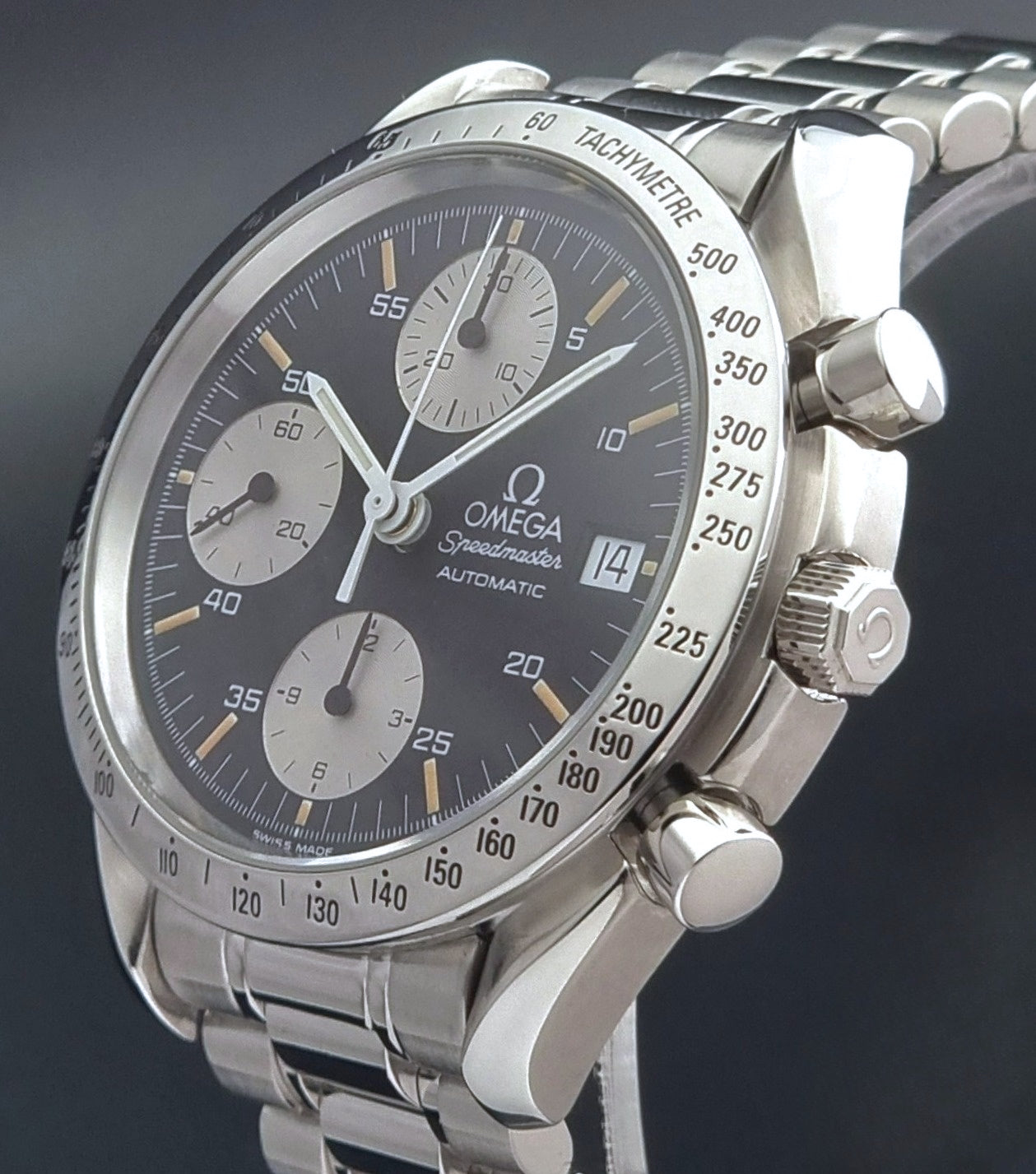 Vintage Omega Speedmaster 3511.50 watch Reverse Panda with a black face on a dark background crown profile view
