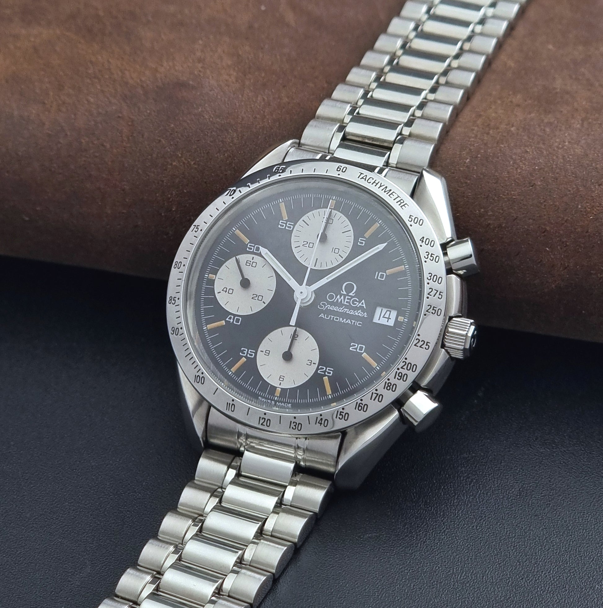 Vintage Omega Speedmaster 3511.50 watch Reverse Panda with a black face on a dark background crown view