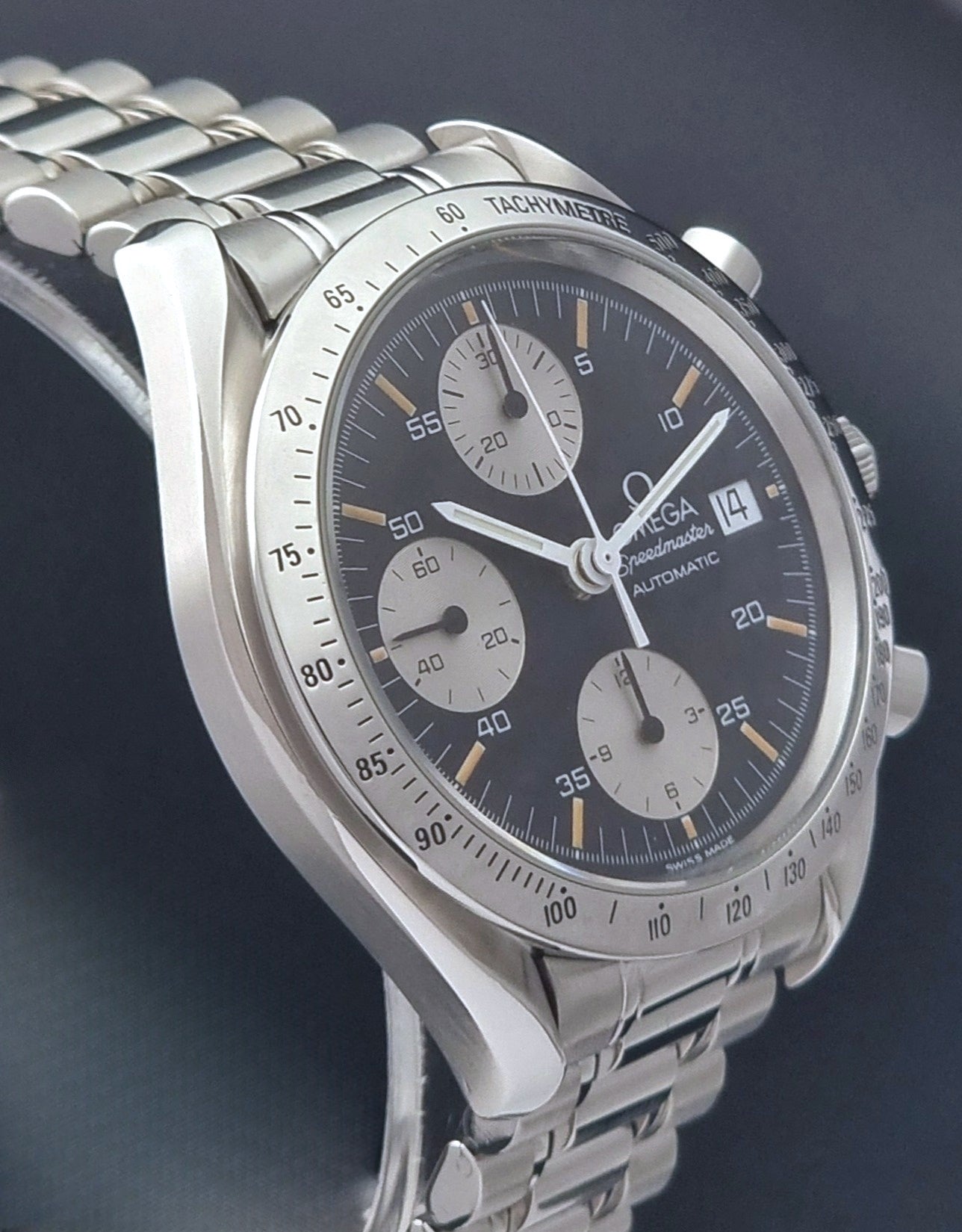 Vintage Omega Speedmaster 3511.50 watch Reverse Panda with a black face on a dark background side profile view