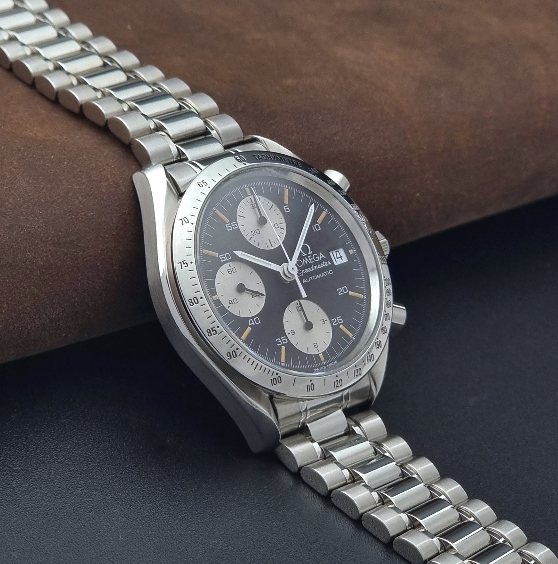 Vintage Omega Speedmaster 3511.50 watch Reverse Panda with a black face on a dark background side view