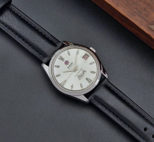Vintage Rado wristwatch Daymaster 11754 with black leather strap on a dark surface dial