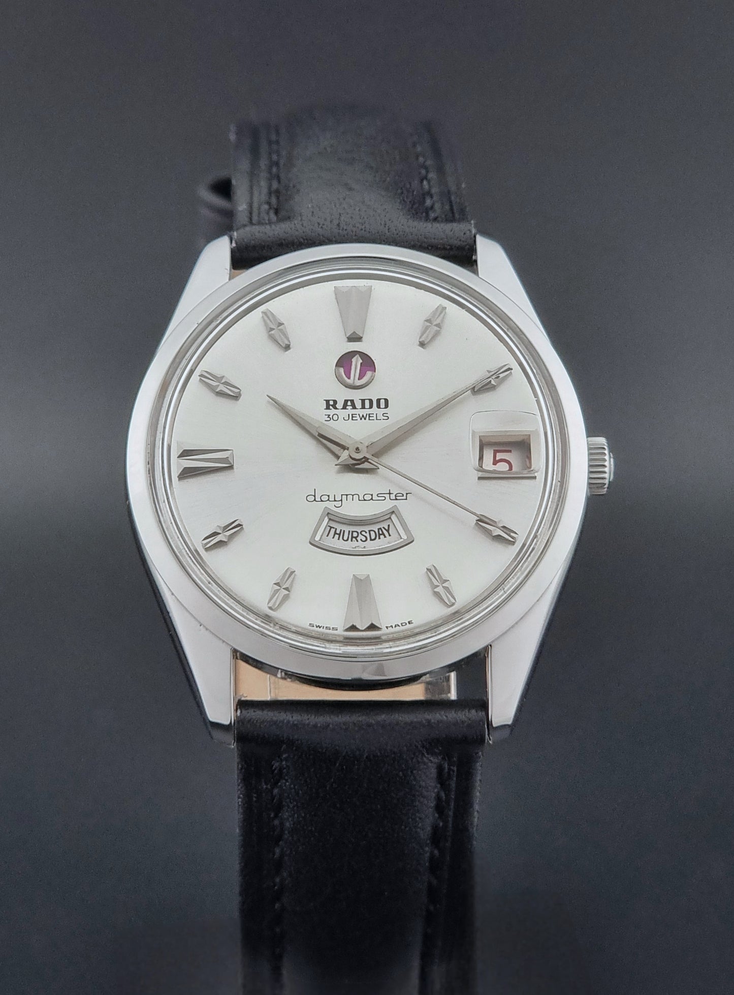 Vintage Rado wristwatch Daymaster 11754 with black leather strap on a dark surface close dial view